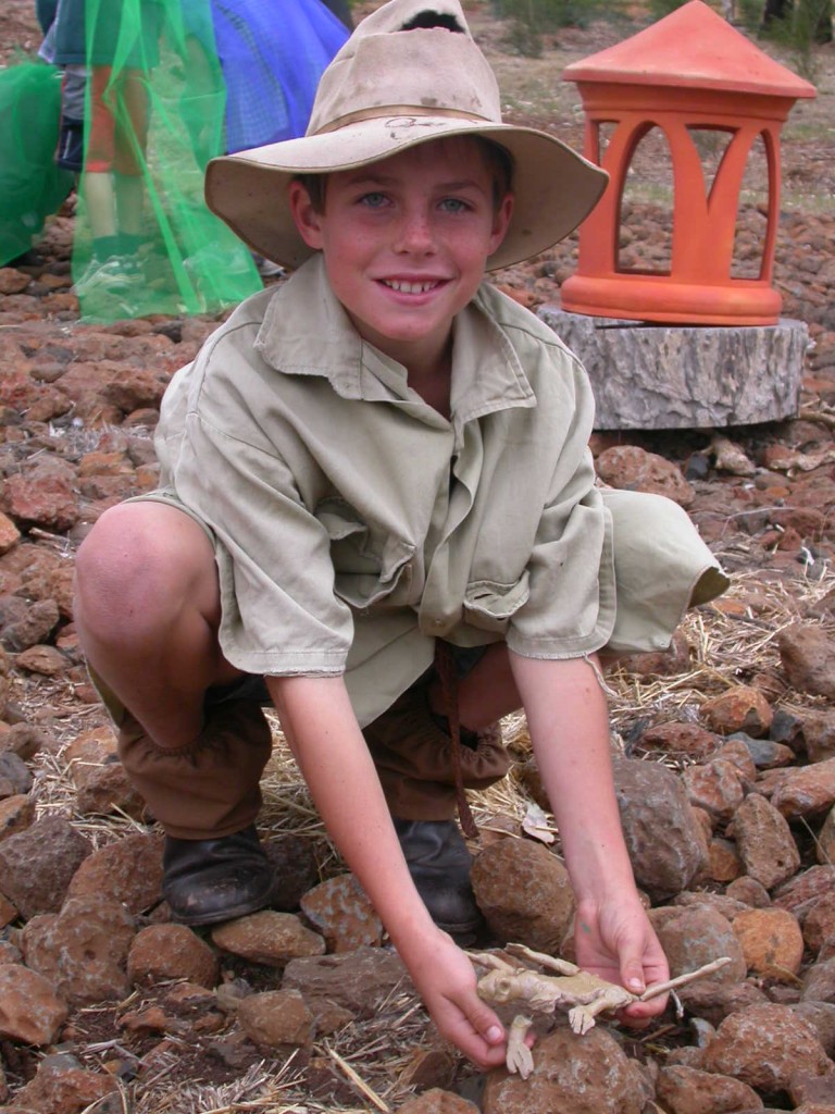 Tom Halford releases a clay dragon into the 'biodiversity area' at Mount Tyson State School during the 'Kids and Dragons' project.
